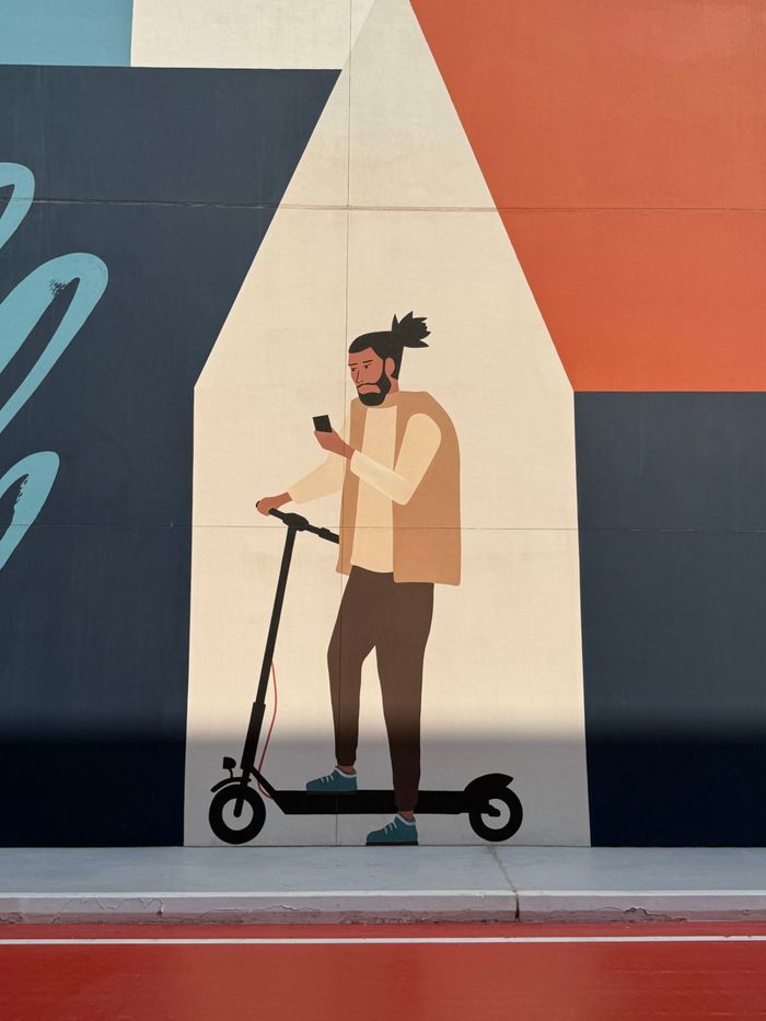 Stylish mural depicting a person on a scooter with smartphone in hand.